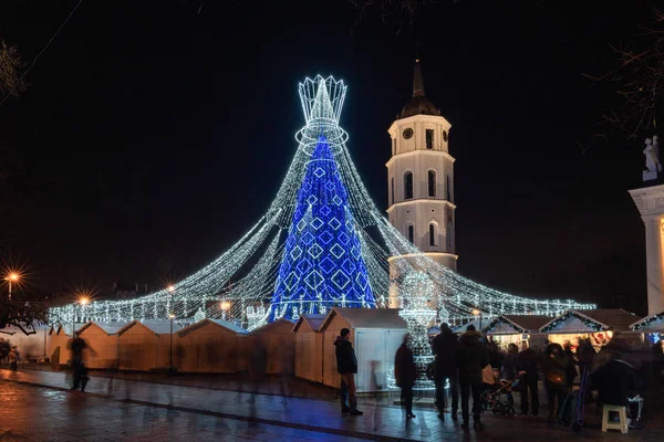 Cathedral square with the most beautiful Christmas tree for Christmas 2019 and New Year 2020 in Europe at night in Vilnius Lithuania. The decorated Christmas tree resembles the 14-15th century Queen figure from the game of chess