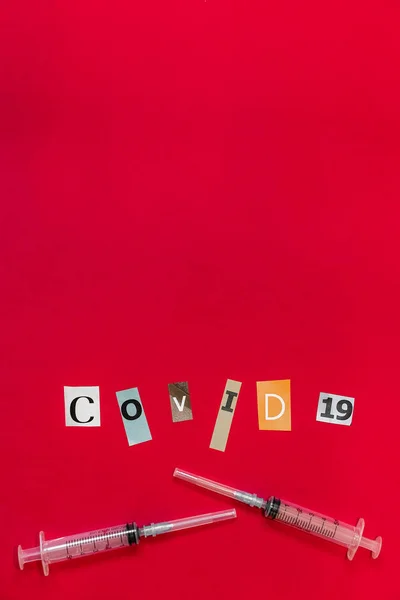 Tıbbi Şırınga Kırmızı Arka Planda Kağıt Kesiği Harflerinden Yapılmış Covid — Stok fotoğraf