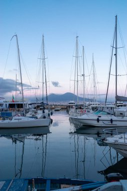 Güzel Napoli Yat İskelesi sıcak bir nisan akşamı İtalya 'nın Campania şehrinde. Şehrin körfezindeki tekne parkında. Uzakta, Vezüv. Mavi saat. Turizm konsepti