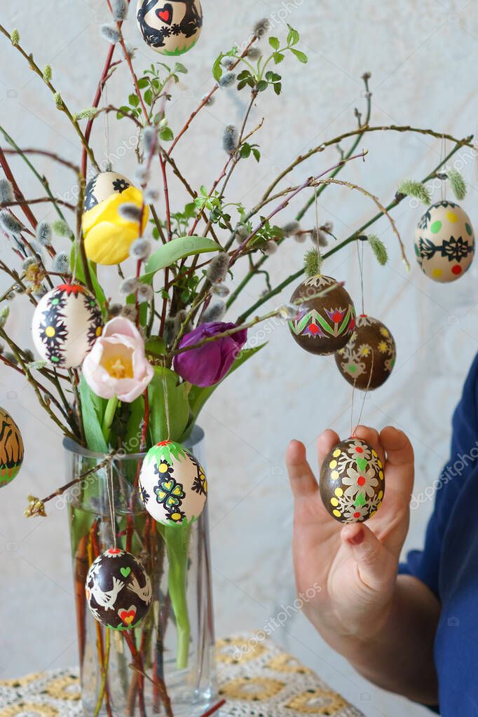 Hermoso ramo de Pascua en un jarrón de vidrio con tulipanes, ramitas de sauce coño y coloridos