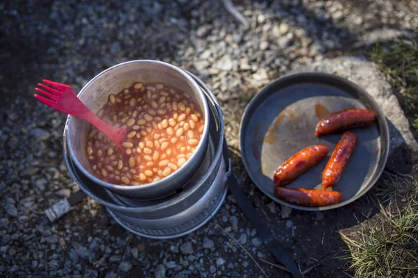 Feijão assado e salsichas na cozinha de acampamento . — Fotografia de Stock