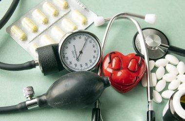 İlaçlar, haplar ve termometre. Stetoskop, vitaminler, turkuaz arka planda duran bir şişe. Eczane alışverişi. Boş yer. Fizyomanometre veya klasik tonometre, tansiyon ölçümü için tonometre.