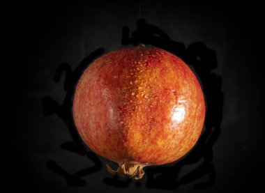 Siyah arka planda sulu kırmızı nar.