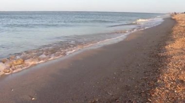 Kumlu bir sahilde ılık bir dalga.