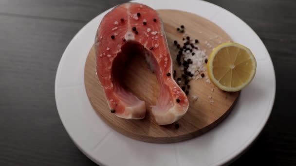 生鲑鱼牛排是烹调用的 黑色木制桌子上的顶视图 — 图库视频影像