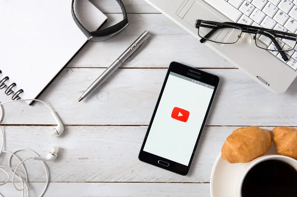 Samsung A5 with YouTube application laying on desk. — Stockfoto