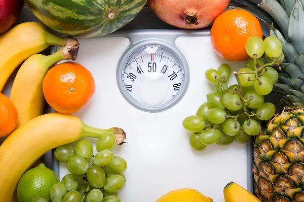 Pila de frutas sobre escala de peso blanco . —  Fotos de Stock