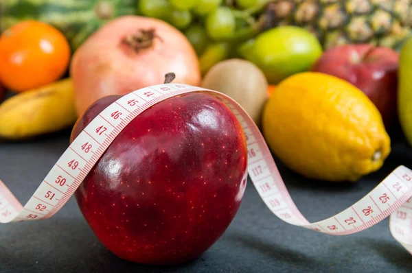 Elma ve meyveli arka plan üzerinde ölçüm bandı — Stok fotoğraf