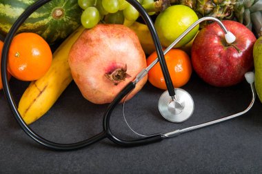 Meyve ve taş tezgah üzerinde stetoskop.