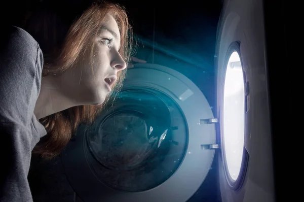 Surprised woman is looking into washing machine. — Stock Photo, Image