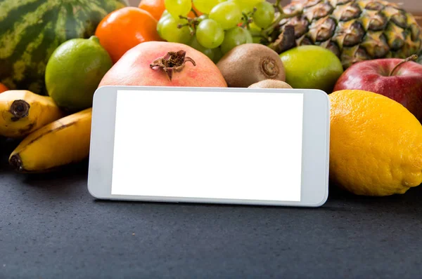 Белый смартфон с пустым экраном на фруктовом фоне — стоковое фото