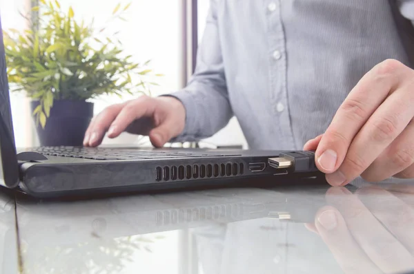 Mann steckt schwarzes HDMI-Kabel in Laptop — Stockfoto