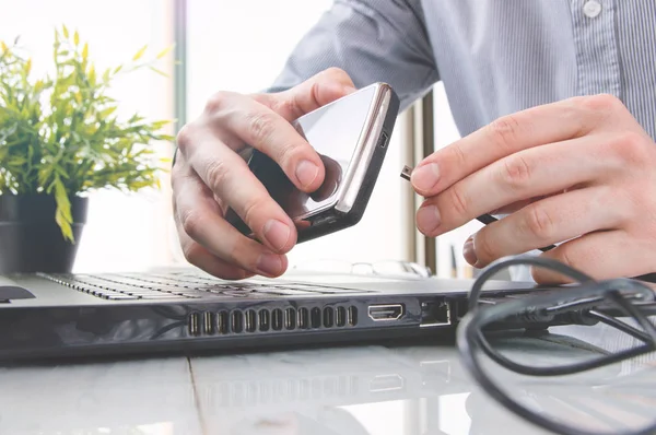 Mann schließt tragbare Festplatte in Laptop ein — Stockfoto