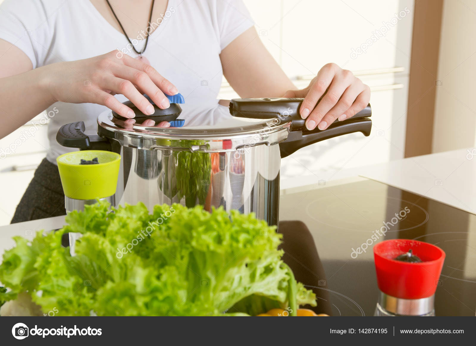 Woman uses pressure cooker to cook a meal. Stock Photo by ©baloon111  142874195