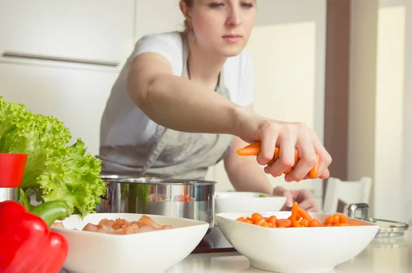 Kvinnen tar gulrøtter for å tilberede et måltid . – stockfoto