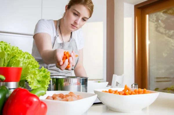 Kadın bir yemek hazırlamak için havuç kullanır. — Stok fotoğraf