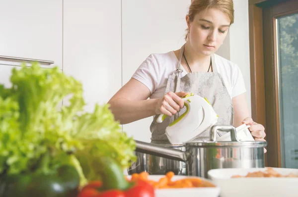 Kadın bir yemek hazırlamak için bir mikser kullanır. — Stok fotoğraf