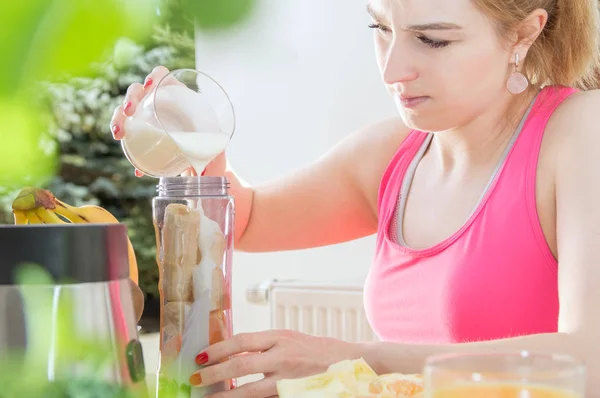 Спортивная женщина держит на столе йогурт со здоровой пищей — стоковое фото