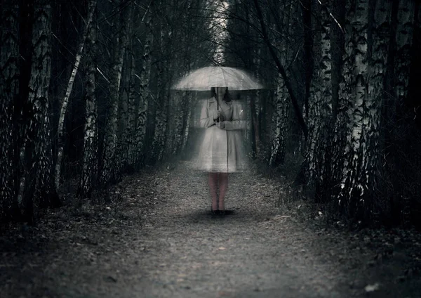 Mujer fantasma se encuentra en un camino oscuro en el bosque —  Fotos de Stock