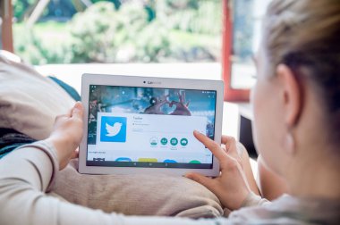 Kadın Lenovo tablet üzerinde Twitter uygulama yükleme.