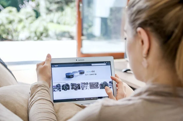 Mujer lanza aplicación amazona en la tableta Lenovo . — Foto de Stock