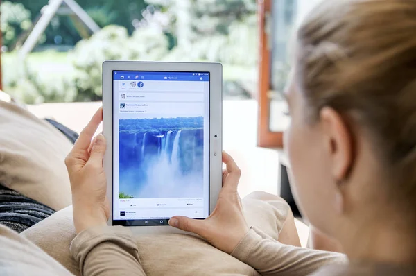Woman launches facebook application on Lenovo tablet. — Stock Photo, Image