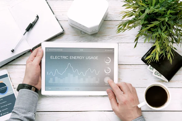 Man håller TabletPC med elektrisk energi användning ansökan — Stockfoto