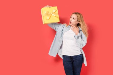 Genç kız bir hediye tutarak ve bakmak