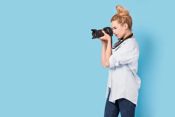 Young blonde photographer is taking a photo. Model isolated on a — Stock Photo, Image