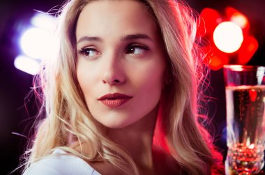 Genç sarışın kız gece partide şampanya kadeh ile