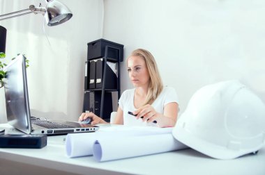 Onun yeni planları ve skeçler sarışın kadın mimar çalışmaktadır