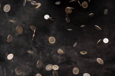 Rain of polish coins on dark background clipart