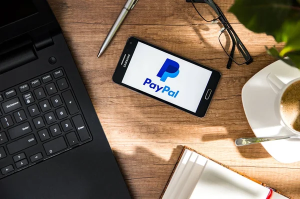 Samsung A5 se encuentra en el escritorio con el logotipo de PayPal en la pantalla . — Foto de Stock