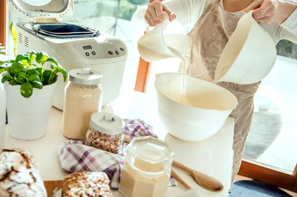 Damen på kjøkkenet lager en deig til å bake hjemmelaget brød med. – stockfoto