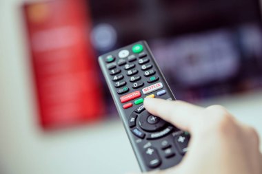  Akış Medya Hizmetleri ile bir Tv uzaktan kumanda kadının elini tutuyor