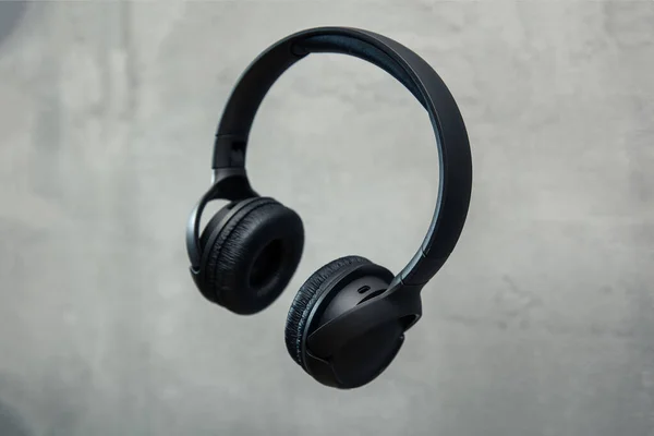 Headphones floates over concrete background — Stock Photo, Image