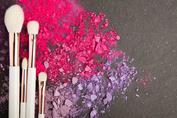 Witte make-up borstels en violet en roze oogschaduwen — Stockfoto
