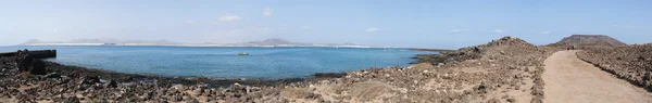 Φουερτεβεντούρα, Κανάριοι Νήσοι, Ισπανία: το μονοπάτι στο βουνό στην Καλντέρα, το αρχαίο ηφαίστειο νησί Lobos (νησίδα de Lobos), ένα μικρό νησί που βρίσκεται μόλις 2 χιλιόμετρα βόρεια από το νησί της Fuerteventura, με θέα του Corralejo — Φωτογραφία Αρχείου