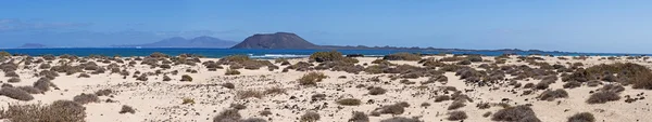 Fuerteventura, Canary islands, Spain: sand dunes on the beach of Grandes Playas (The Big Beaches), one of the famous beaches for kitesurfing and windsurfing, with Lobos Island, a small island 2 km north of Fuerteventura