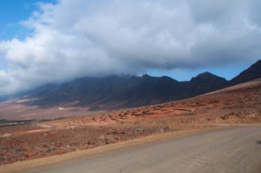 Fuerteventura, Kanarya Adaları, İspanya: taş duvarlar toprak yol toplaya üzerinde de Cofete, 30 kilometre plaj adanın Morro del Jable korunan alan Jandia doğal parkında parçası en etkileyici Dağları tarafından desteklenen