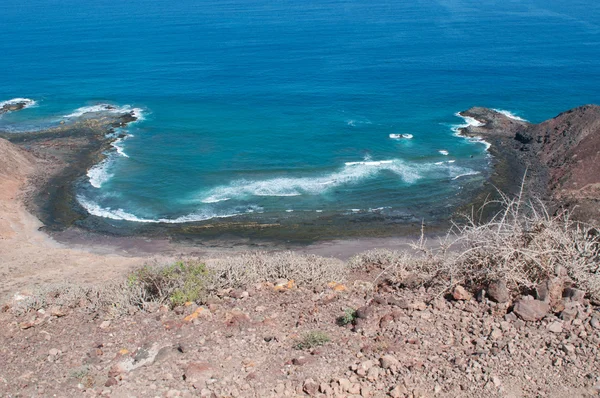 Fuerteventura, Islas Canarias, España: la playa negra vista desde lo alto de la montaña de la Caldera, el antiguo volcán de la Isla de Lobos (Islote de Lobos), una pequeña isla situada a solo 2 kilómetros al norte de la isla de Fuerteventura — Foto de Stock