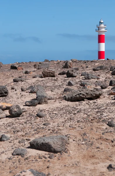 Fuerteventura, Islas Canarias, España: rocas negras y vista del Faro de Toston (faro de Toston o faro de El Cotillo), un faro activo en Punta de la Ballena cuya estructura original fue inaugurada en 1897 — Foto de Stock