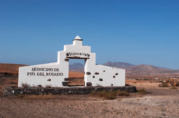 Fuerteventura, Ilhas Canárias, Espanha: montanhas e paisagem desértica com o sinal do município de Puerto del Rosario construído na forma de uma casa colonial espanhola — Fotografia de Stock
