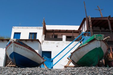 Fuerteventura, Kanarya Adaları, İspanya: tekneler ve Beyaz Saray üzerinde siyah beach, Pozo Negro, bir balıkçı köyü olan siyah beach lav tarafından oluşturulduğu Turistlik uzak akar milyonlarca yıl önce