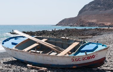 Fuerteventura, Kanarya Adaları, İspanya: bir tekne üzerinde siyah beach, Pozo Negro, bir balıkçı köyü olan siyah beach lav tarafından oluşturulduğu Turistlik uzak akar milyonlarca yıl önce