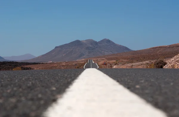 Canarische eilanden Fuerteventura, Spanje: uitzicht op de woestijn en het vulkanische landschap van het asfalt op de weg tot Pozo Negro, een klein vissersdorp uit de buurt van de plaatsen overbevolkt door toeristen zien — Stockfoto