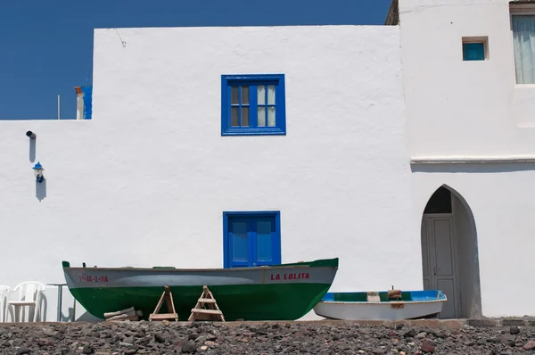 Fuerteventura, Îles Canaries, Espagne : les bateaux et une maison blanche sur la plage noire de Pozo Negro, un village de pêcheurs loin des lieux touristiques dont la plage noire a été créée par la lave coule il y a des millions d'années — Photo
