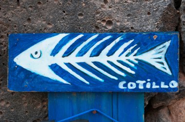 Fuerteventura, Kanarya Adaları, İspanya: bir fishbone ve El Cotillo, ünlü balıkçı köyü adanın kuzeybatısında siyah kayalarda asılı yazılı Cotillo ile bir ahşap panel 