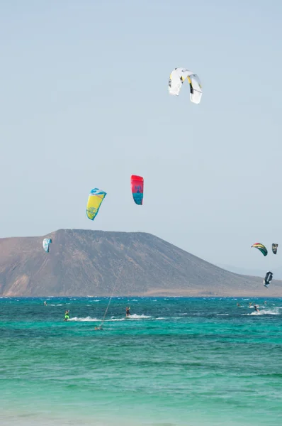 Fuerteventura, Islas Canarias, España: kitesurf en la playa de Grandes Playas, una de las famosas playas de kitesurf y windsurf, con vistas a la isla de Lobos, una pequeña isla a 2 km al norte de Fuerteventura — Foto de Stock