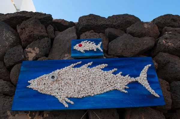검은 바위에 매달려 물고기와 나무 패널 — 스톡 사진